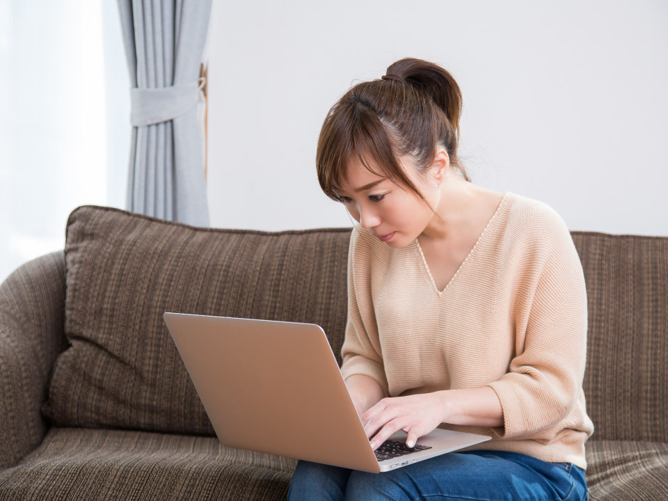 猫背の状態でPCを使用している女性の画像