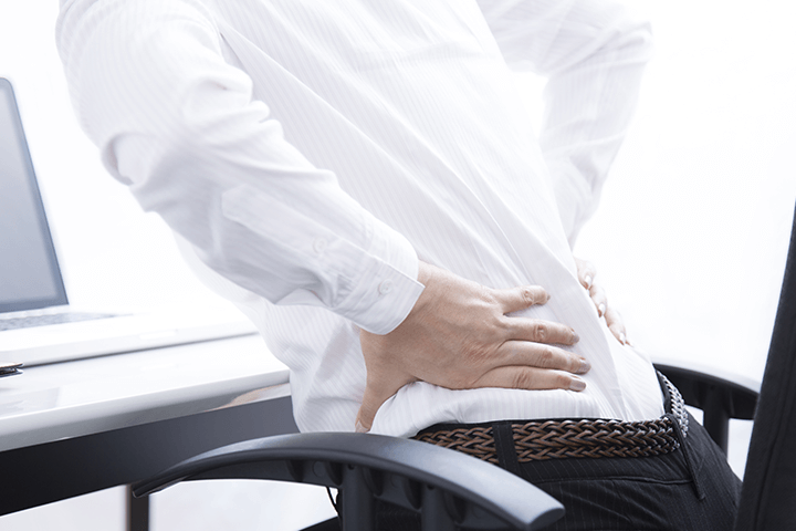 長時間のデスクワークで腰が痛い写真
