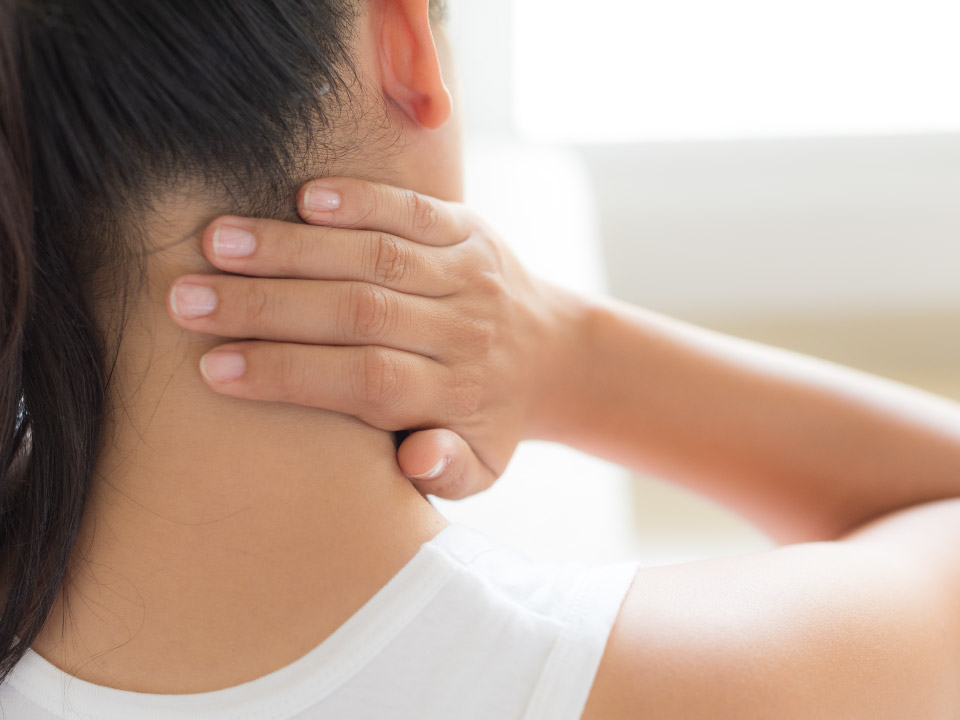 首の痛みに悩む女性の画像